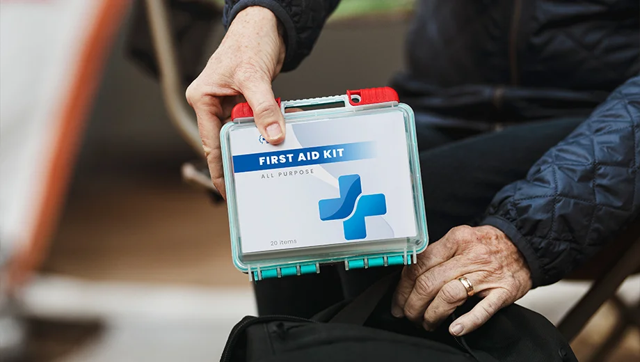 A man retrieves a first aid kit from his backpack.